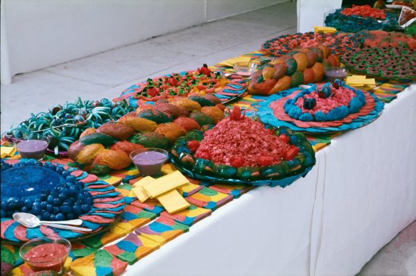 Bright multi-coloured food, arranged carefully on platters on a long table.