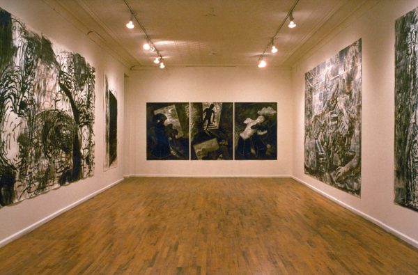 Five series of ink and charcoal drawings on paper, mounted on the walls of a gallery. The drawings feature dark and distorted, faceless human figures, and expressive lines and forms.